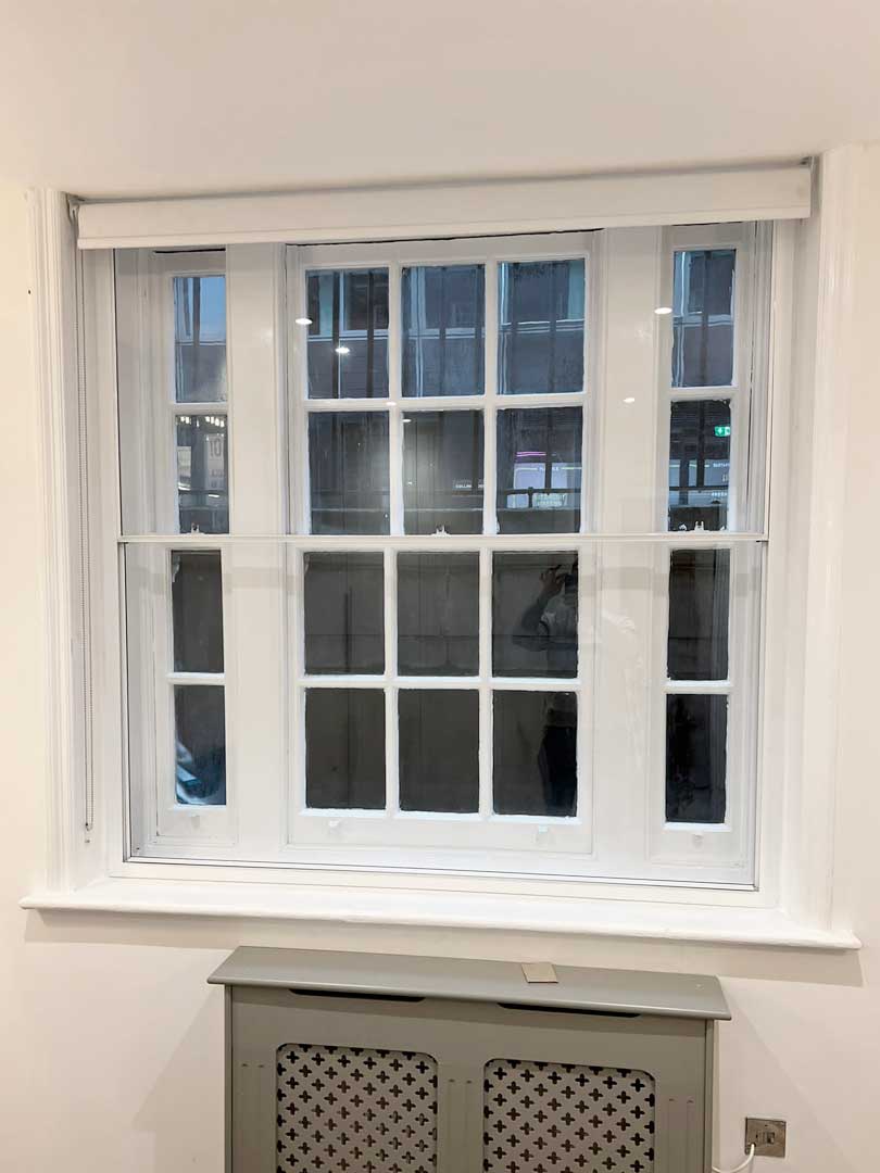 Custom vertical sliding sash heritage aluminium window with a traditional grid pattern and modern double glazing.