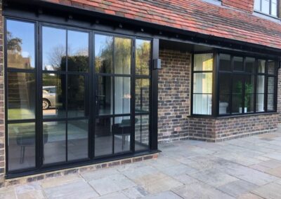 Heritage aluminium windows and doors with slim black frames installed on a brick house.