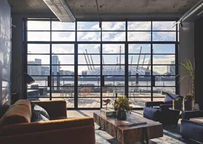 Modern living room with floor‑to‑ceiling aluminium windows overlooking the O2 Arena.
